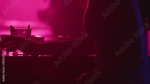 Woman glass on bar in pink light