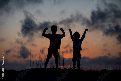 Sunset silhouette of two boys 