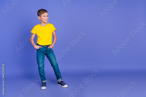 Full length photo of cute nice adorable boy arms pockets wear yellow stylish clothes look empty space isolated on violet color background