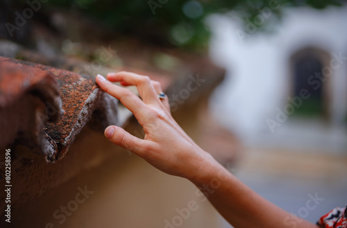 Female hand gently touches weathered tiles photo