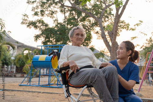 Wallpaper Mural Young nurse and elderly asian senior woman on wheelchair, Asian careful caregiver and patient,  Nurse gives a pep talk to an elderly female patient in the garden in the evening. Health insurance. Torontodigital.ca