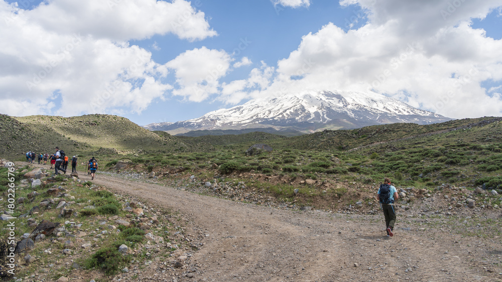 Hikers walking to the basecamp with snowy mountain summit in backdrop, Mount Ararat in Turkey