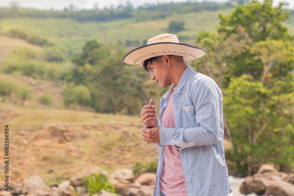 lifestyle: latin peasant with straw hat in the countryside