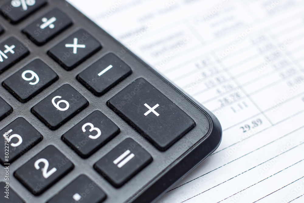 Close up of a calculator on top of a sheet of paper Close up of a calculator on top of a sheet of paper