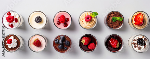 flat lay composition of gourmet dessert shooters and mini parfaits in elegant glassware on a white background.