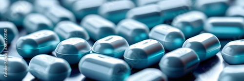 Blue capsules scattered on a surface, highlighting pharmaceutical use. Healthcare and medicine web banner