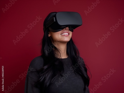 A smiling woman wearing VR headset against red background, exploring virtual worlds. © cherezoff