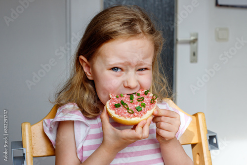 Mettbrotchen. girl eats a bun with raw pickled minced meat. traditional german breakfast. photo