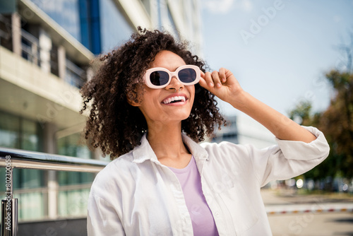 Photo of cheerful pretty lovely good mood girl traveler tourist walking megapolis watchin beautiful modern architecture photo