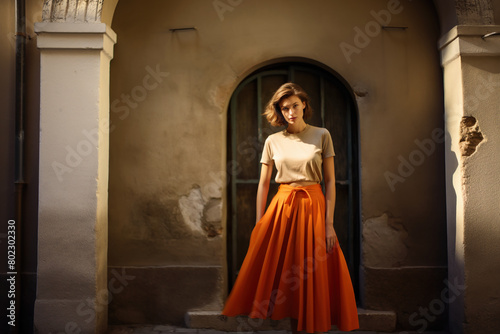 Beautiful woman wearing an orange pleated skirt. © July P