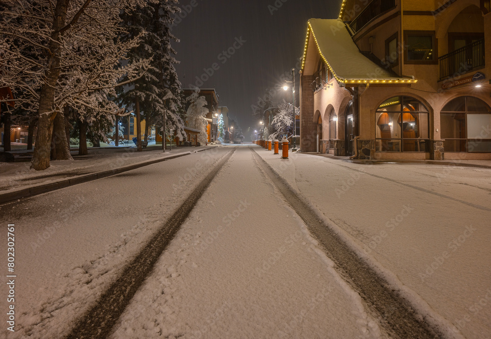 Early morning tire tracks on a snow-covered street in Canmore, Alberta, Canada