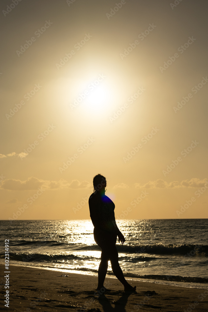 photo of muscular woman silhouette against light at sunset on the Cuban Caribbean beach modeling
