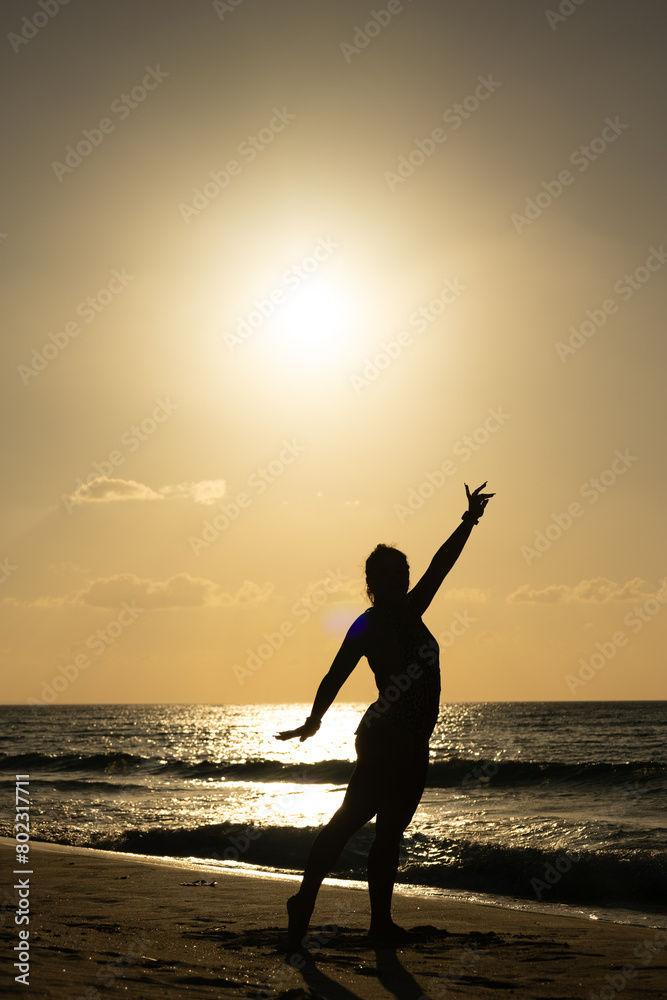 photo of muscular woman silhouette against light at sunset on the Cuban Caribbean posing