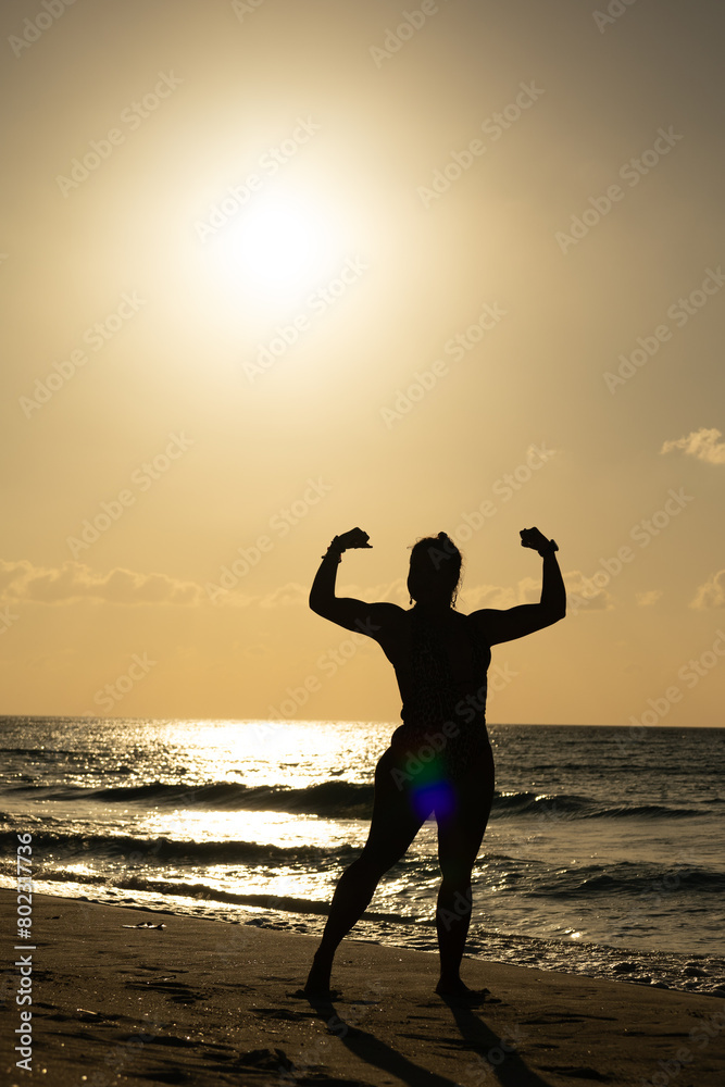 photo of muscular woman silhouette against light at sunset on the Cuban Caribbean beach