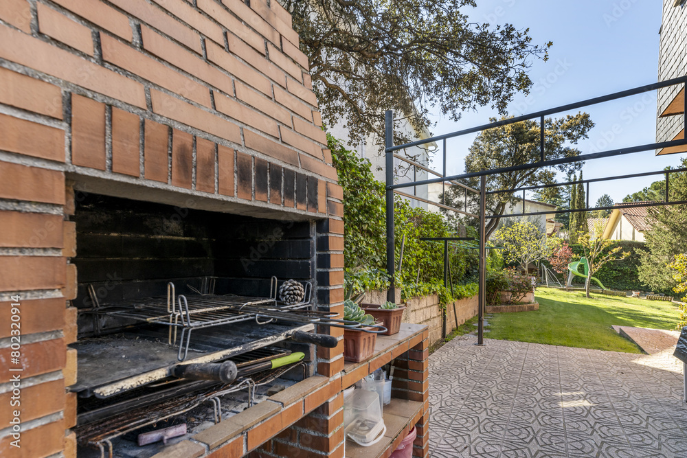 built-in barbecue with garden vines with a tiled path and a garden with grass in the background built-in barbecue with garden vines with a tiled path and a garden with grass in the background
