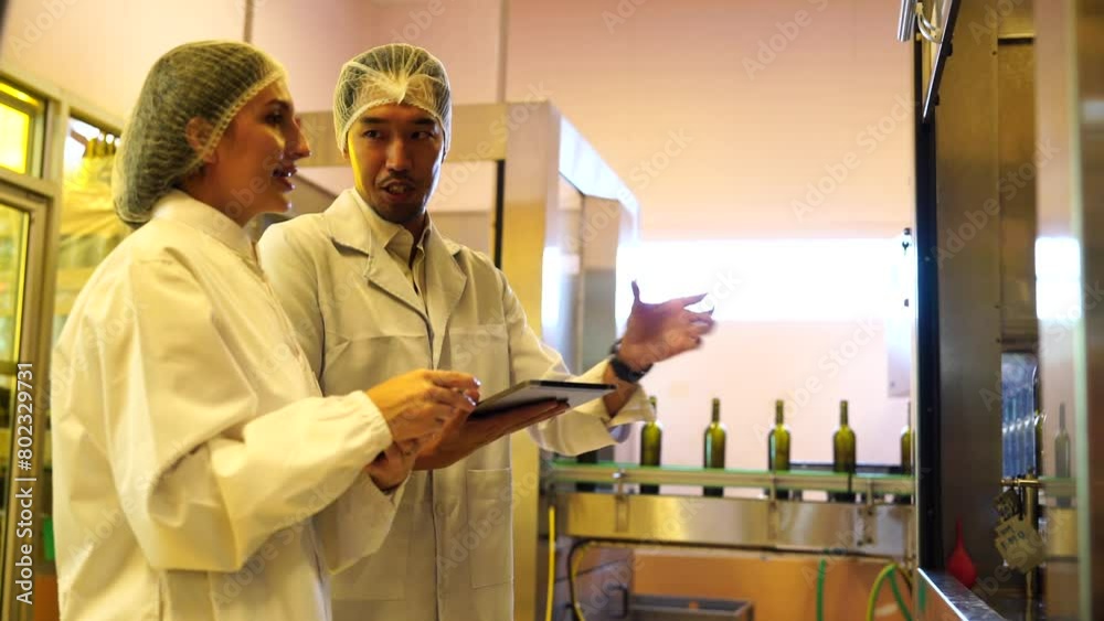 Technicians and female winemakers are experts in wine quality inspection visit to inspect the quality of grape fermentation tanks and check the temperature of wine with laptop production in the factor