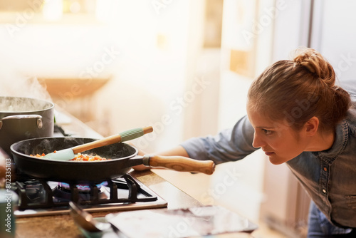 Tableau sur toile Woman, cooking and pan of food on gas stove in kitchen, preparing meal and culinary at home