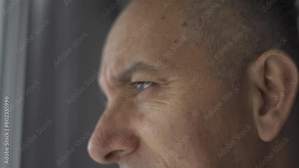 close-up of an adult male looking out the window close-up of an adult male looking out the window