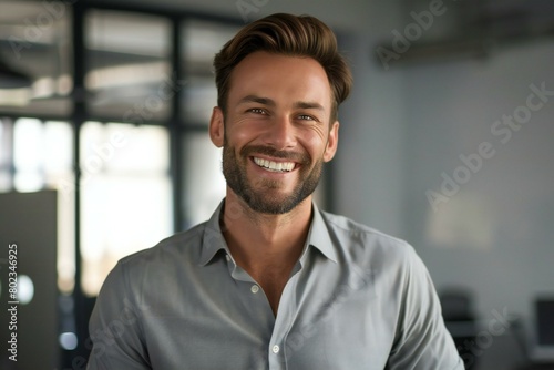 Portrait of smiling young businessman looking at camera in a modern office