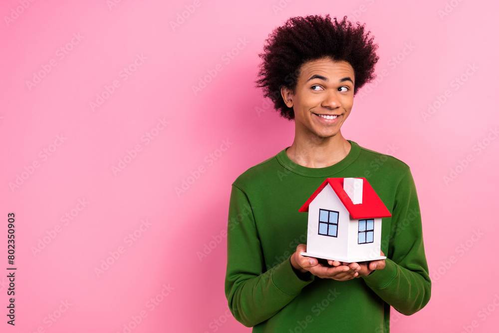 Photo of happy positive guy hold house building look empty space isolated over pastel color background Photo of happy positive guy hold house building look empty space isolated over pastel color background
