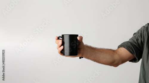 A Hand Holding a Black Mug