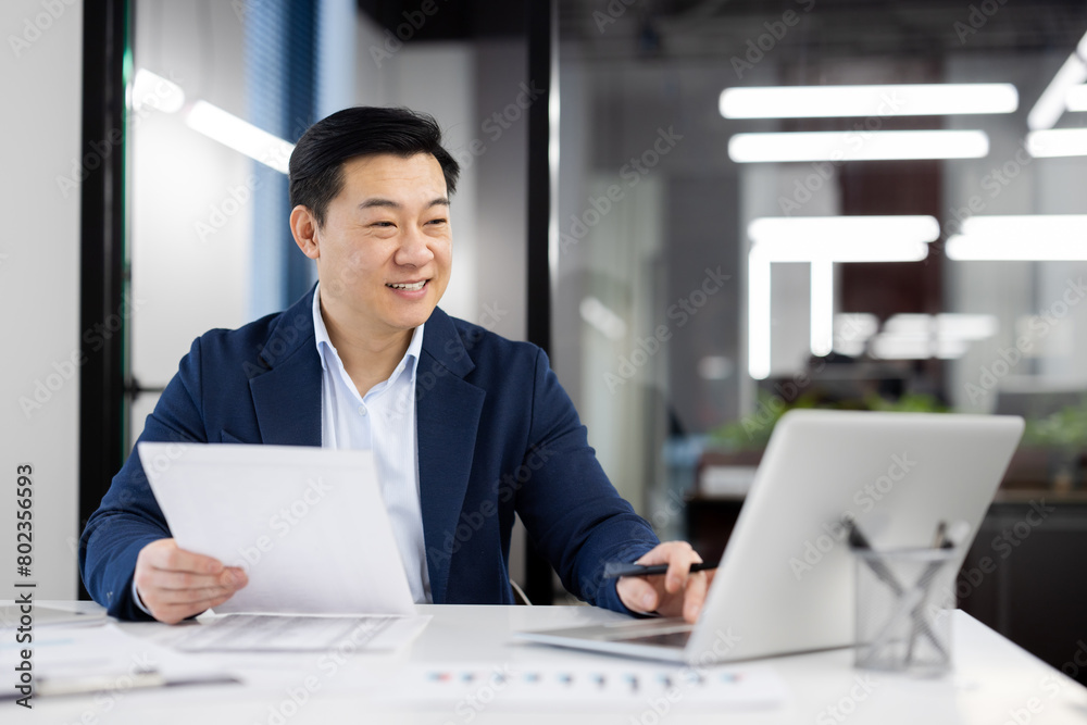 Happy person in formal clothes working by table with pc on background of modern office interior. Busy administrator accomplishing list of daily tasks and sending email with project report. Happy person in formal clothes working by table with pc on background of modern office interior. Busy administrator accomplishing list of daily tasks and sending email with project report.