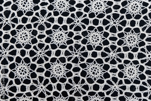 Vintage handmade white knitted napkin isolated on a black background.