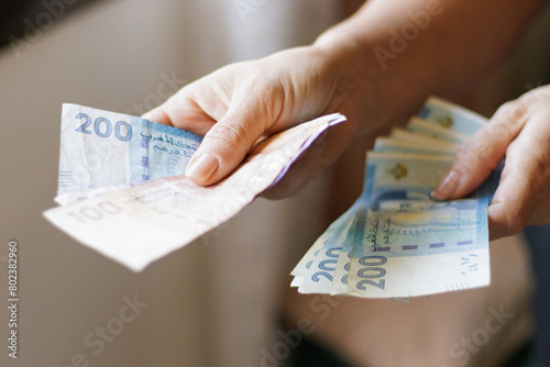Hand holding Moroccan banknotes, dirham official currency of Morocco