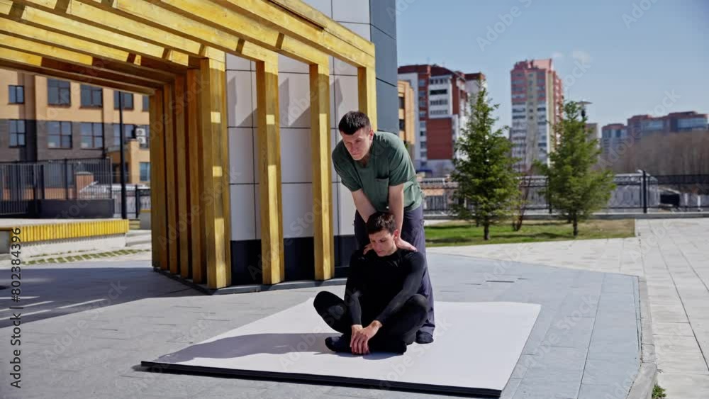 custom made wallpaper toronto digitalTherapist in green shirt assisting client during therapy session outdoors on mat under wooden structure near river.