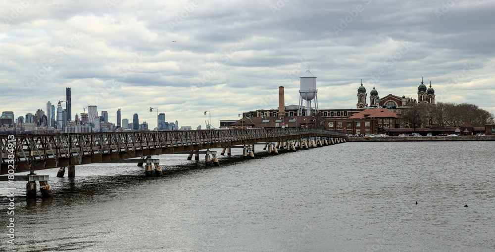 ellis island view with bridge and hudson river (from liberty state park in jersey city nj) new immigrant arrival museum historical site dark dramatic sky cloudy (york history immigration europe)