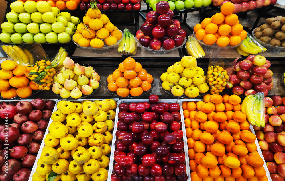 Apples, pears, pomegranates, bananas, oranges, grapes, kiwis, persimmons and other fruits on display at the market