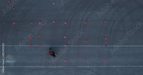 Training of motorcyclists. Improve the driving skills of motorcycle drivers. Aerial view. Motorcyclists drive between traffic cones, Drone view photo
