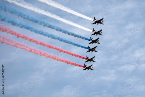MOSCOW, RUSSIA - MAY 7, 2021: Avia parade in Moscow. Group of Russian fighters Sukhoi Su-25 with painted russian flag in the sky on parade of Victory in World War II in Moscow, Russia