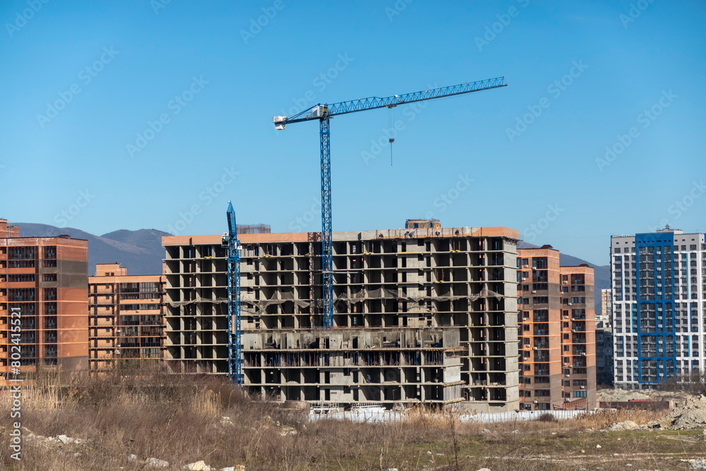 Fototapeta premium Novorossiysk Two hoisting cranes and buildings under construction
