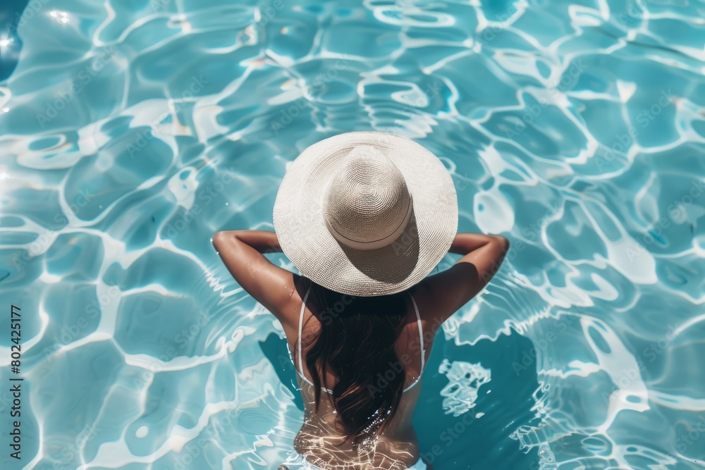 woman relaxing in the pool wearing a sun hat