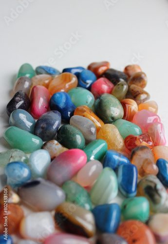 Heap Of Scattered Colorful Gemstones Receding Into The Distance On White Background Vertical Image
