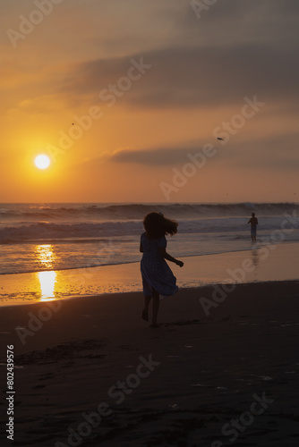 Young girl dancing in the sand silhouette during sunset in Lima Peru