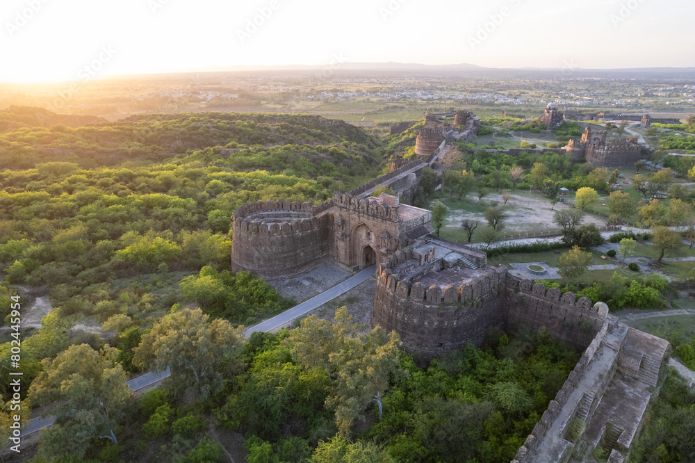 Aerial view of the main gate of Rohtas fort on green hill during sunset.
