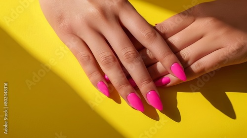 Womans hands with pink nail design. Manicure, pedicure beauty salon concept. Deep long shadows.