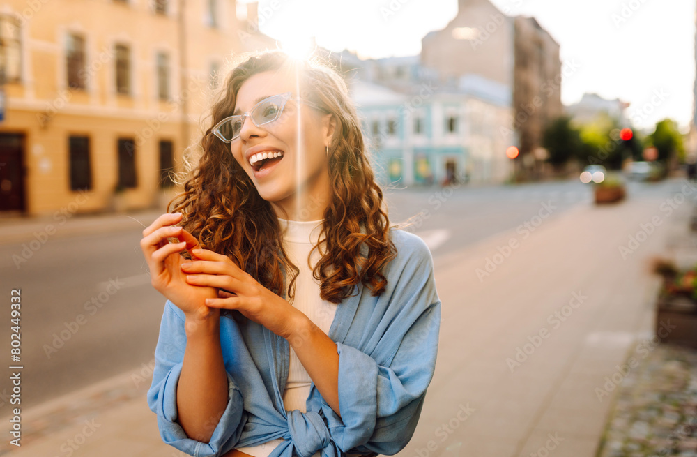 Fashionable young  woman in good mood posing outdoors.  Sunny day. Concept of lifestyle, fashion, travel.
