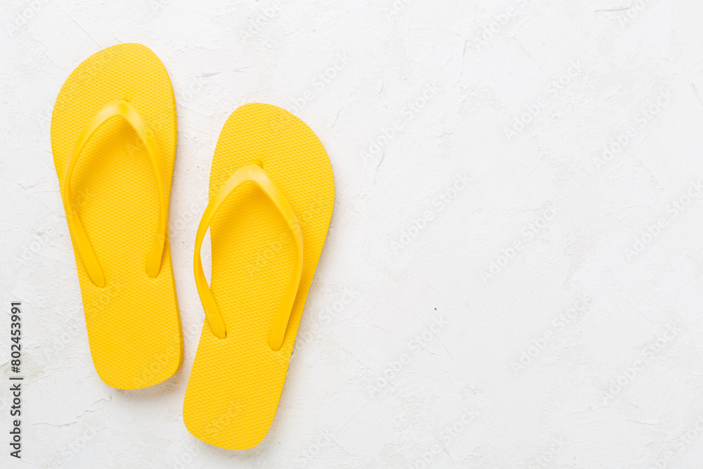 Bright yellow flip-flops on concrete background, top view. Summer concept Bright yellow flip-flops on concrete background, top view. Summer concept
