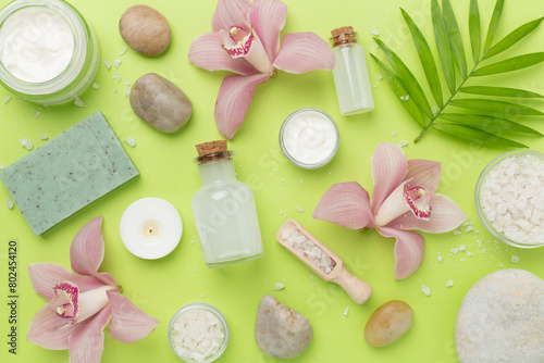 Composition with orchids and massage stones on color background, top view