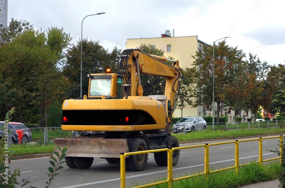 Yellow excavator on the road