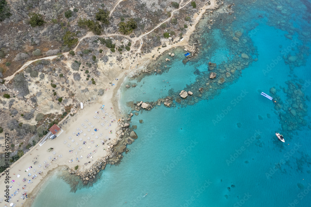 Drone view of idyllic sandy holiday beach. Konnos Bay beach people relaxing and enjoying summer holidays.