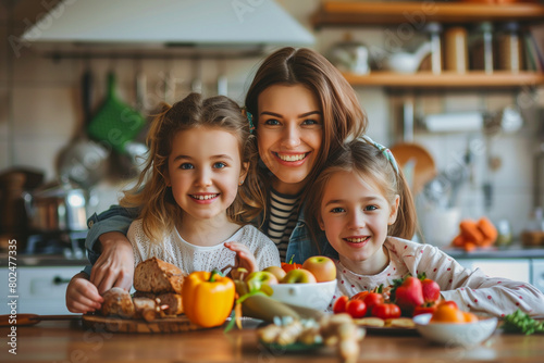 Happy Family Cooking Together in Kitchen. A mother and her two daughters enjoy preparing healthy meals together in a cozy  well-equipped kitchen.