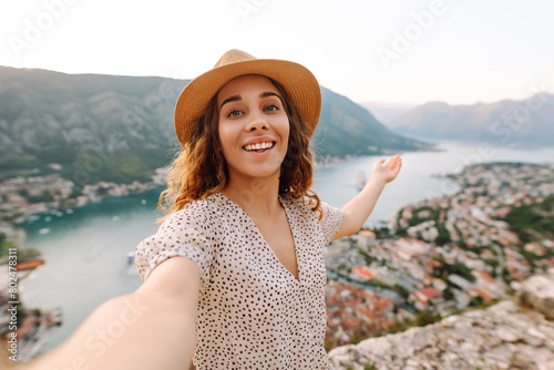 Happy tourist  with a mobile phone, takes a selfie, communicates via video link  against the backdrop of attractions. Lifestyle, travel, rest, weekend, active life.