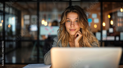 Bella donna mentre lavora con un pc portatile in un moderno ufficio photo