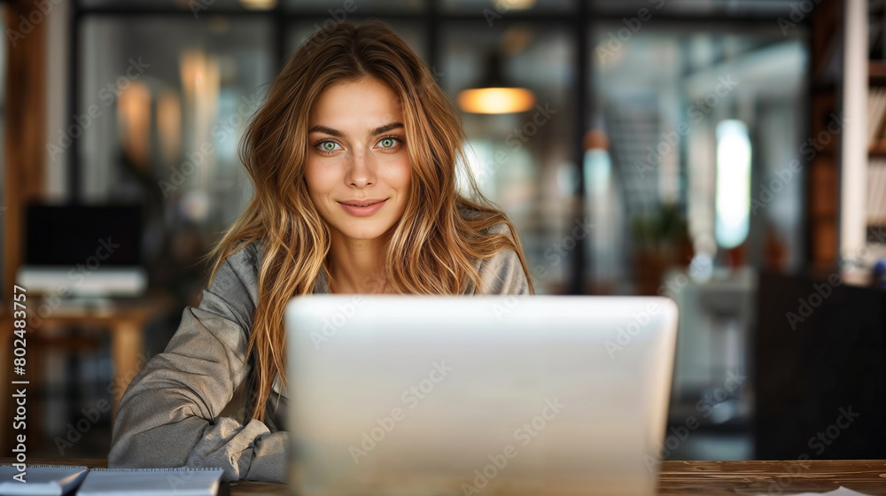 Bella donna mentre lavora con un pc portatile in un moderno ufficio