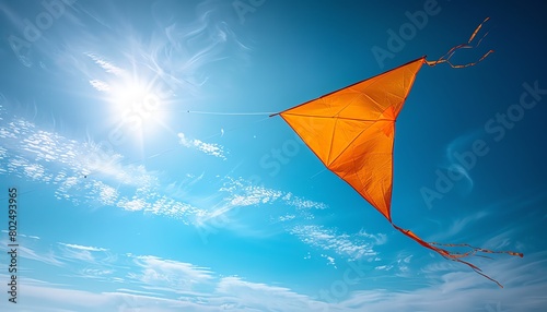 Yellow kite flying high in a clear blue sky, closeup, freedom, carefree joy