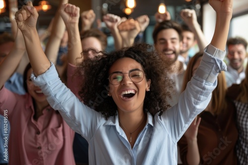 Excited young african american businesswoman in eyeglasses raising hands in celebration, celebrating victory in office. Successful businesswoman with raised hands celebrating success.